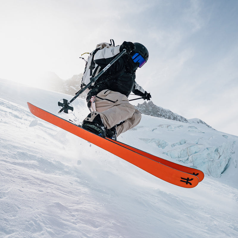 Skier jumping with black and green freeride and touring ski boots phaenom fr 130 and orage Faction touring skis Agent 3