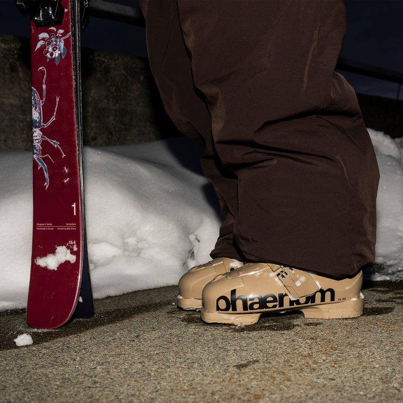 Phaenom fs 02 110 person standing with boots in frame and tails of skis next to them